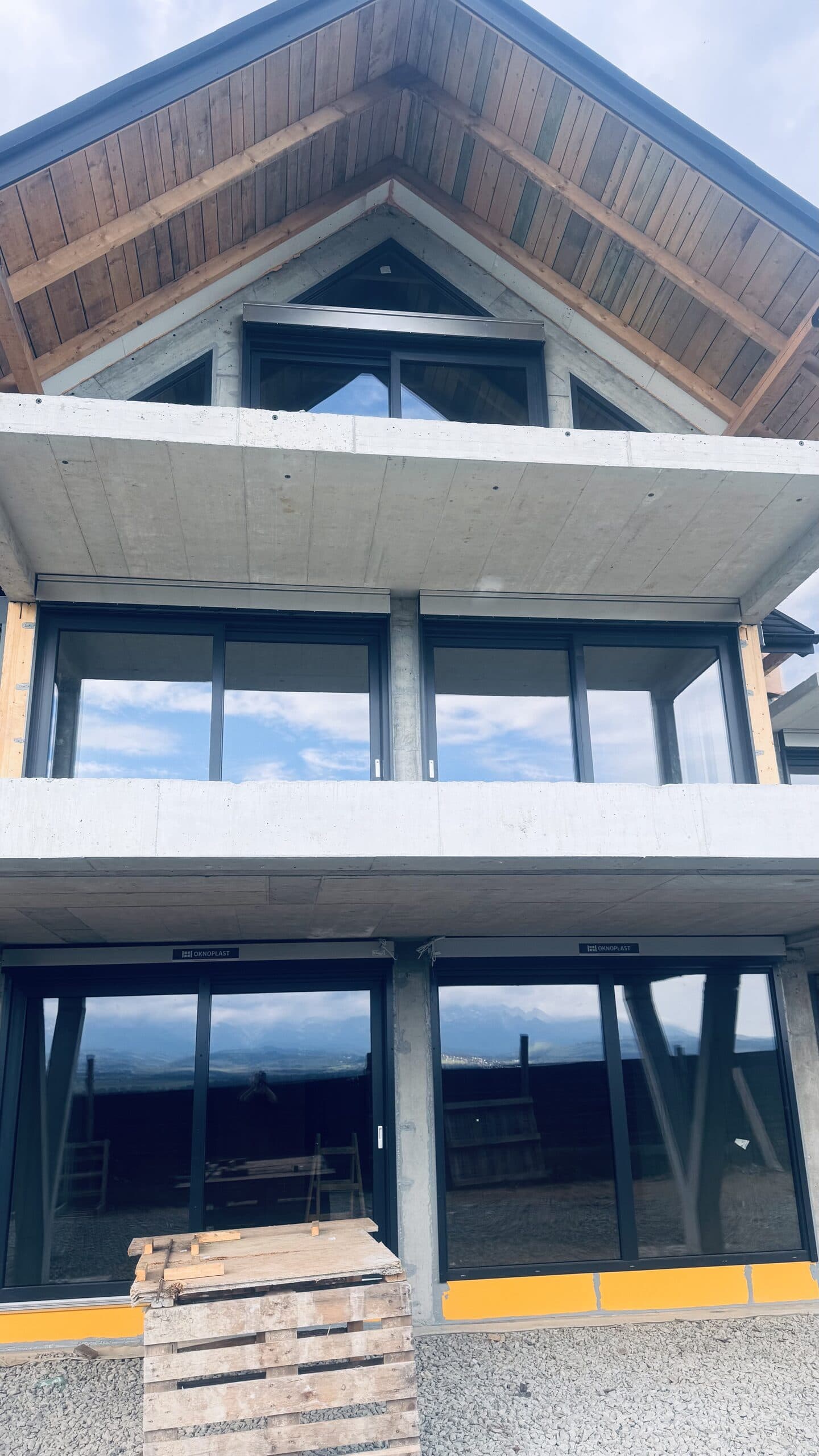 Fasada domu górskiego — aluminiowe okna antracyt i drewniana więźba dachowa